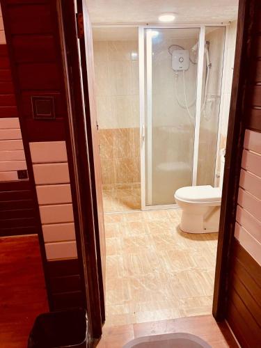 a bathroom with a toilet and a glass shower at Anandas Beach Resort in Trincomalee