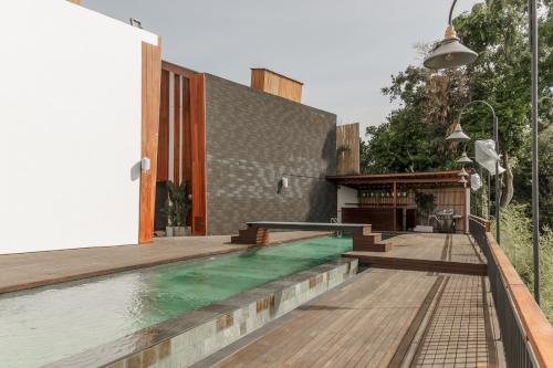 a house with a swimming pool and a wooden deck at Sunny Cuddles in Canggu