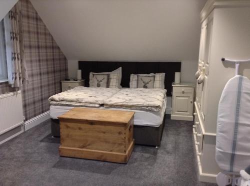 a bedroom with a large bed with a wooden box at The BurnHowf apartment in Balloch