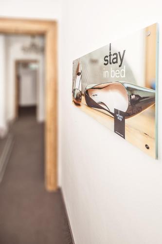 a sign that says stay in bed with a shoe on a wall at Urban Stay Salzburg City in Salzburg