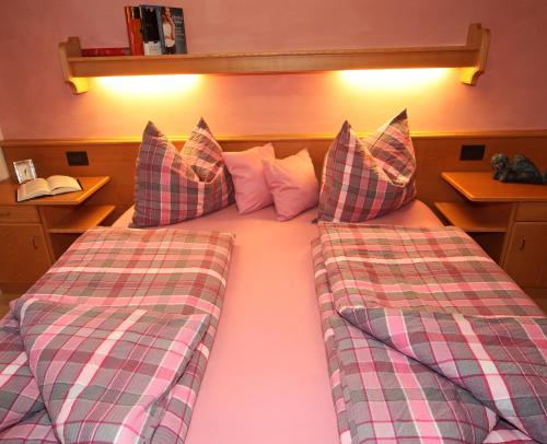 a bedroom with two beds with plaid pillows at Residence Sas Vanna in La Villa