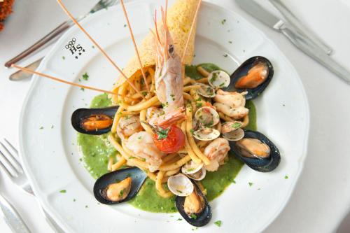 a plate of food with shrimp pasta and mussels at Hotel Sandra in Rimini
