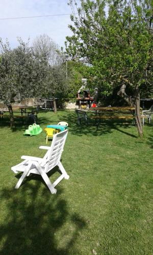 a white chair sitting in the grass in a yard at La Magnolia - Fano in Fano