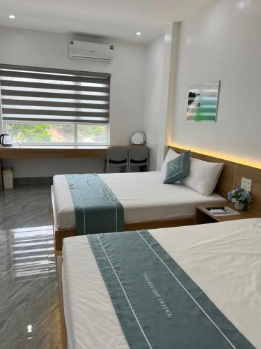 a hotel room with two beds and a window at Thành Đạt Hotel in Dao Co To