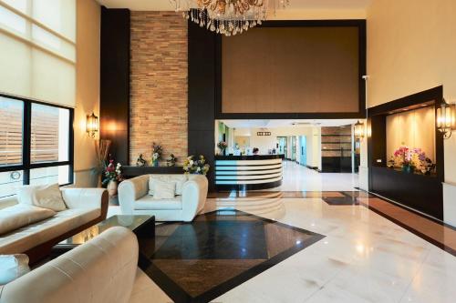 a living room with couches and a chandelier at 42Grand Residence in Bangkok