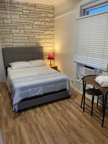 a bedroom with a bed and a brick wall at PRIVATE ROOM ON TAYLOR FULL KITCHEN and BATHROOM shared ARTS RooSEVELT ROW CONVENTION CENTER STADIUMS ASU DOWNTOWN PHOENIX in Phoenix