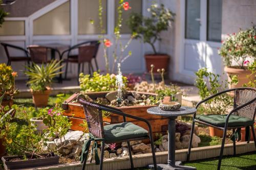 a patio with a table and chairs and a garden at Durakovic Apartments in Herceg-Novi