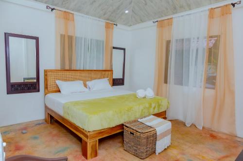 a bedroom with a large bed with a yellow blanket at Casa Verde in Puerto Viejo