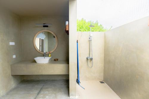 a bathroom with a sink and a mirror at Kitesurfing Lanka in Kalpitiya