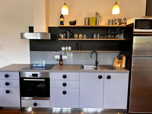 a kitchen with a sink and a stove at THE DEVLIN APARTMENTS 2 Bedroom Apartment near GMHBA stadium in Geelong - G04 in Geelong