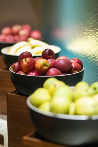 a group of bowls of apples and bananas on display at Beijing Xixi Friendship Hotel nearby Xidan Shopping Street, Tian'An Men Square, Forbidden City, Houhai & Jingshan Park in Beijing