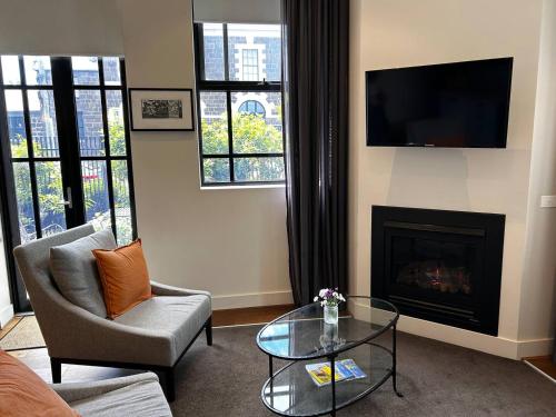 a living room with a fireplace and a tv at THE DEVLIN APARTMENTS 2 Bedroom Apartment near GMHBA stadium in Geelong - G04 in Geelong