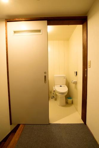 an open door to a bathroom with a toilet at Chalet Myoko in Myoko