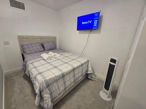 a bedroom with a bed with a tv on the wall at Bedroom with TV in Upland E in Edmonton