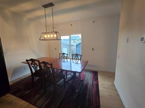 a dining room with a wooden table and chairs at Bedroom with TV in Upland E in Edmonton