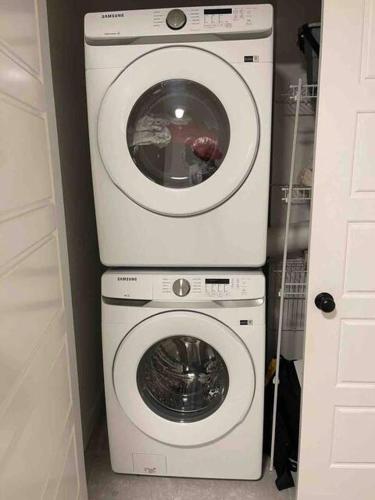 a washing machine and a dryer in a room at Bedroom with TV in Upland E in Edmonton