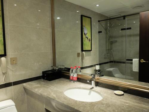 a bathroom with a sink and a bath tub at Beijing Xixi Friendship Hotel nearby Xidan Shopping Street, Tian'An Men Square, Forbidden City, Houhai & Jingshan Park in Beijing