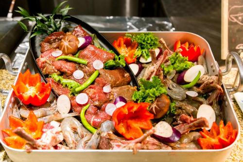 a pan of food with vegetables in it at Beijing Xixi Friendship Hotel nearby Xidan Shopping Street, Tian'An Men Square, Forbidden City, Houhai & Jingshan Park in Beijing