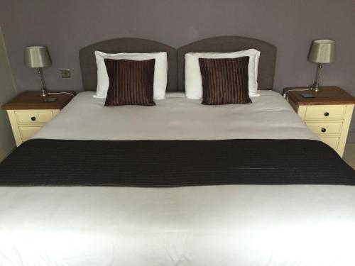 a bedroom with a large white bed with two night stands at The Clyffe Hotel in Lowestoft