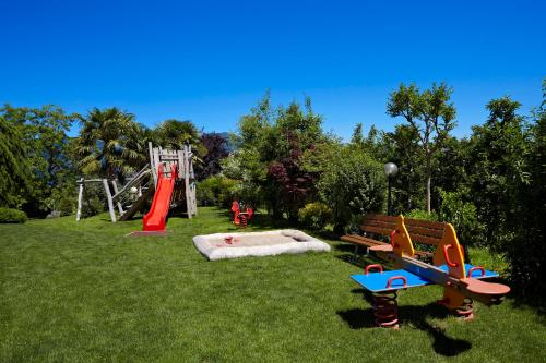 a park with a playground with a slide and a bench at Hotel Girlanerhof in Appiano sulla Strada del Vino