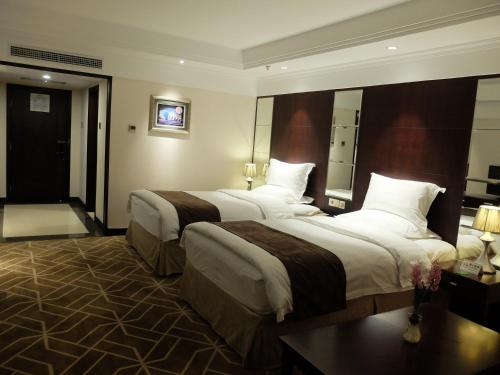 a hotel room with two beds and a mirror at Beijing Xixi Friendship Hotel nearby Xidan Shopping Street, Tian'An Men Square, Forbidden City, Houhai & Jingshan Park in Beijing