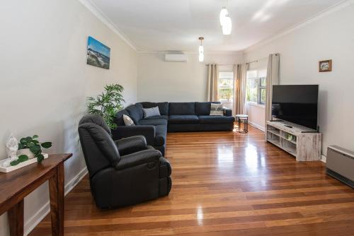 a living room with a couch and a television at Beach Retreat on Kent- Bikes, Large Backyard, Gas BBQ in Busselton