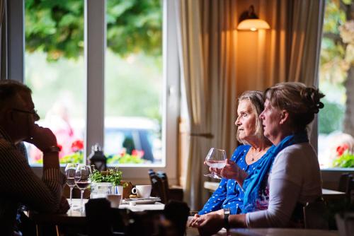 a group of women sitting at a table with wine glasses at In den Roden Leeuw van Limburg in Wittem