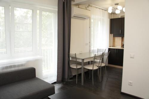 a kitchen and dining room with a table and chairs at Meretskova Apartment in Velikiy Novgorod