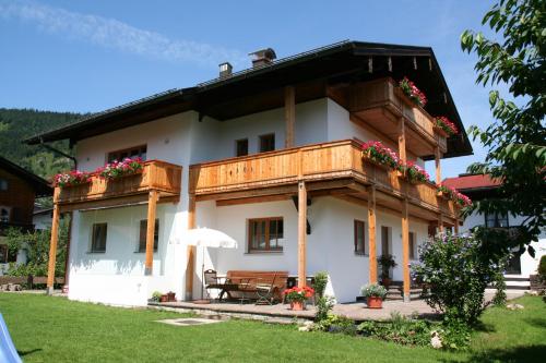 a large white house with a wooden balcony at Haus Bergblick in Reit im Winkl