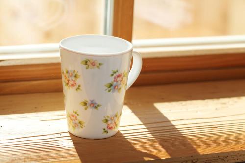 a white coffee cup sitting on a window sill at Haus Bergblick in Reit im Winkl