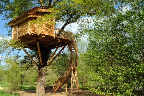 a wooden tree house in a tree at La Cabane du Vieux Chêne in Susmiou