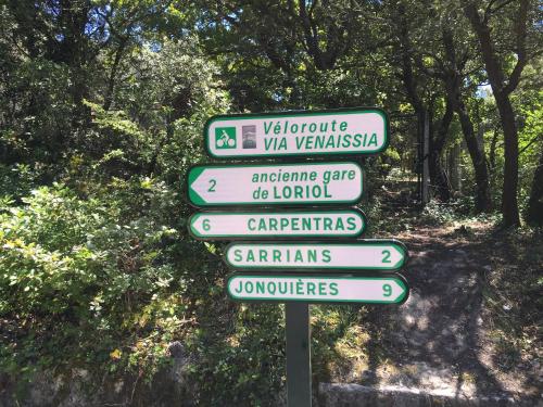 a street sign with several signs on a trail at Domaine Lafayette in Loriol-du-Comtat