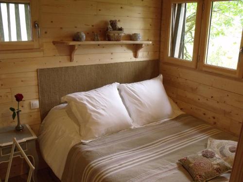 1 dormitorio con 1 cama en una cabaña de madera en La Cabane du Vieux Chêne, en Susmiou