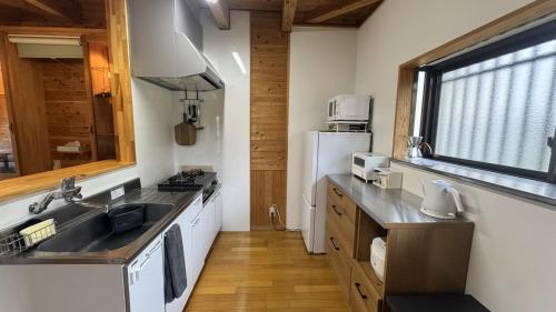 a kitchen with a sink and a refrigerator at 日田天ヶ瀬の源泉掛け流し温泉付き貸別荘 5名様まで同料金 in Hita