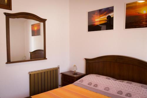 a bedroom with a bed and a mirror at Apartment Sole e Mare in Galižana
