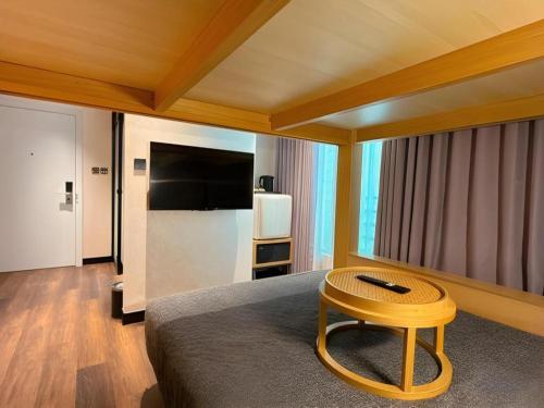 a room with a bed with a table and a television at Harbour Bay Hotel in Hong Kong