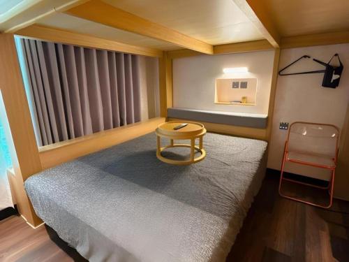 a room with a bed with a table and a chair at Harbour Bay Hotel in Hong Kong