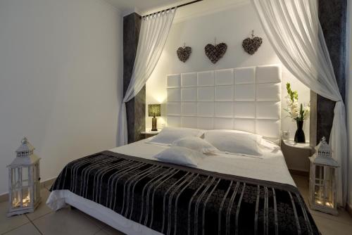 a bedroom with a large bed with a white headboard at Dream Island Hotel in Fira