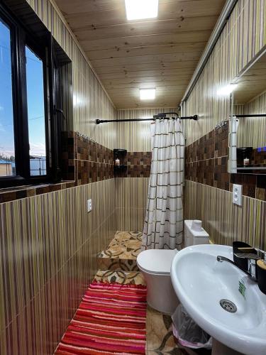 a bathroom with a sink and a toilet and a sink at Ethno Guest House Caravan Tamchy in Tamchy