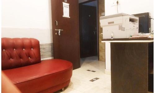 una sedia in pelle rossa seduta in una stanza con una scrivania di Hotel Ganesh Pashu-Patinath inn Gorakhpur AC OR NON AC ROOM UP a Gorakhpur