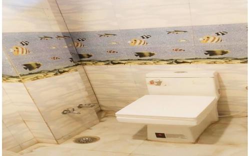 un bagno con un water e dei pesci sul muro di Hotel Ganesh Pashu-Patinath inn Gorakhpur AC OR NON AC ROOM UP a Gorakhpur