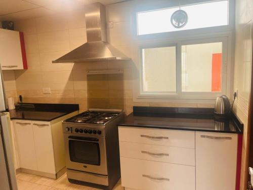 una cocina con estufa horno superior al lado de una ventana en 2 Bedroom Apartment, en Mascate