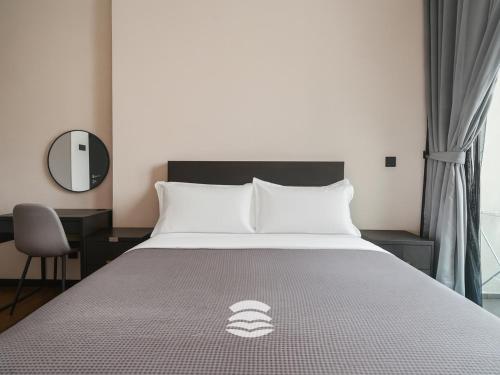 a bedroom with a large white bed with a mirror at Opus by Soulasia in Kuala Lumpur