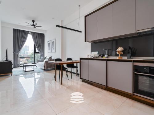 a kitchen with white cabinets and a dining room at Opus by Soulasia in Kuala Lumpur