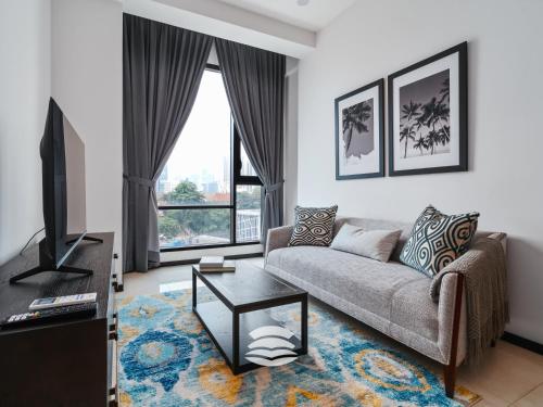 a living room with a couch and a tv at Opus by Soulasia in Kuala Lumpur
