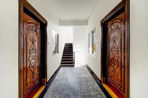 a hallway with two wooden doors and a staircase at Super Collection O DLF CyberCity Hyderabad Formerly Key Suites in Kondapur