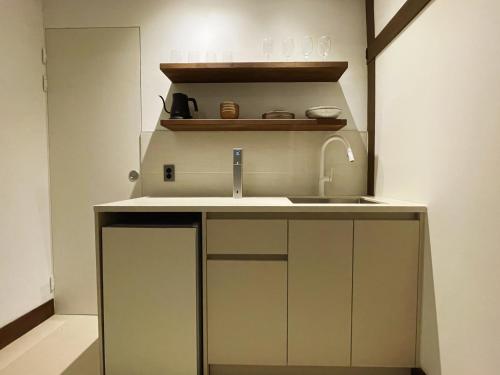 a small kitchen with a sink and a mirror at Hanok Stay - Ladam in Jeonju