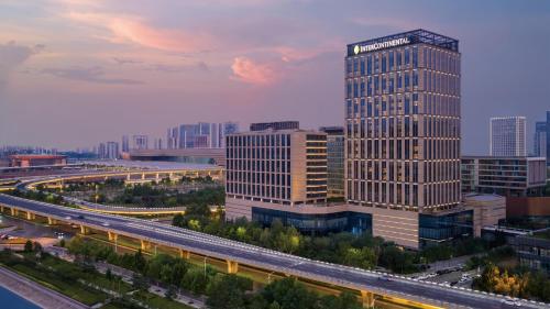 a tall building in a city with a highway at InterContinental Hotels Zhengzhou Zhengdong in Zhengzhou