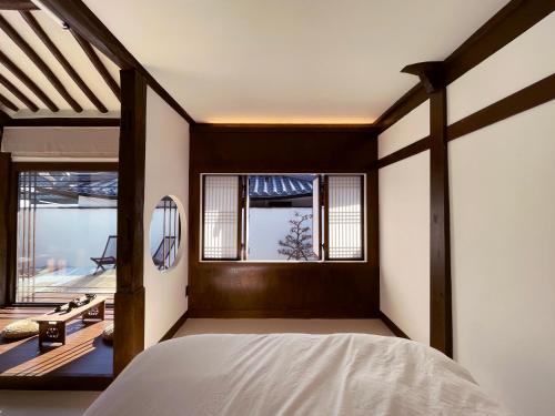 a bedroom with a bed and a window at Hanok Stay - Ladam in Jeonju