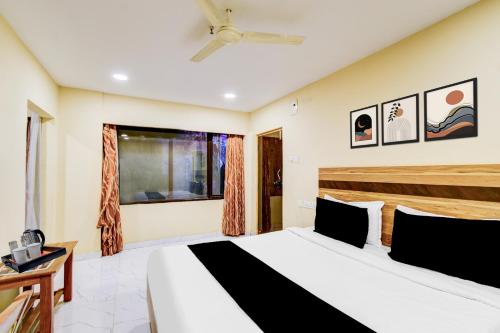 a bedroom with a bed and a ceiling fan at Super Collection O Victoria Memorial Metro Station Formerly Shanthaa Residency in Surūrnagar